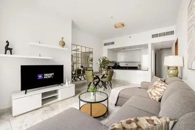 a living room with a couch and a tv at Stunning 1BR at Noora Tower, Al Habtoor City in Dubai