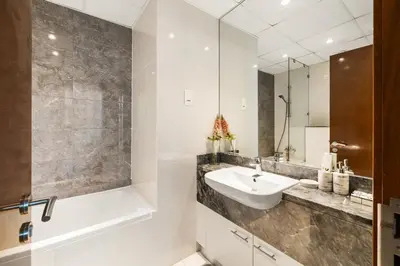 a bathroom with a sink and a tub and a mirror at Stunning 1BR at Noora Tower, Al Habtoor City in Dubai