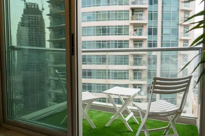 a table and chairs on a balcony with a window at Werova - Luxury 2BR Apartment w Breathtaking View in Dubai