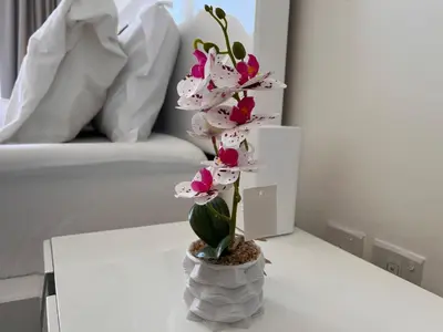 a vase filled with pink and white flowers on a table at Modern 1BR Apartment Golf View Gym Pool in Dubai
