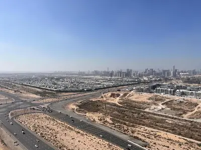 an aerial view of a highway and a city at Modern 1BR Apartment Golf View Gym Pool in Dubai