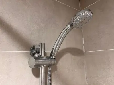 a shower with a shower head in a bathroom at Modern 1BR Apartment Golf View Gym Pool in Dubai