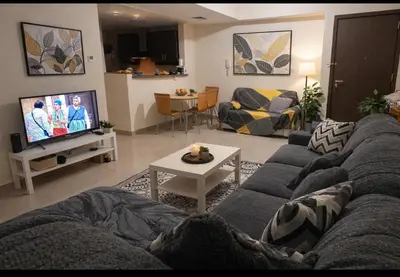 a living room with a couch and a tv at Luxury Entire 3 bed rooms with 3 bathrooms in Dubai