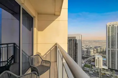 a balcony with a chair and a view of a city at 30th Floor Creek Harbour 1 Bedroom Apartment in Dubai
