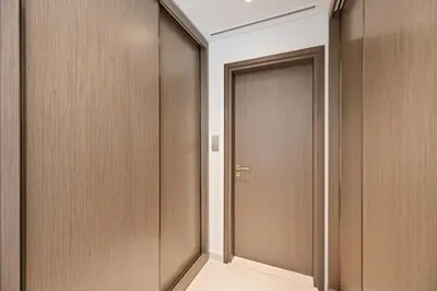 a corridor with wooden doors in a building at Grand Bleu by Elie Saab Residency, Private Beach - Dubai Harbour - 2BR in Dubai