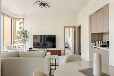 a white living room with a couch and a table at Oshima LIV Marina 1BR Marina View in Dubai