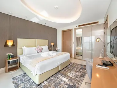 a bedroom with a large white bed and a desk at Sky-high 1Br Apartment Sleeps 4 in Damac Paramount in Dubai