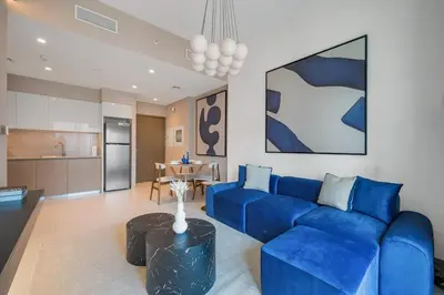 a living room with a blue couch and a table at Downtown Suite Trendy 1BR -Dubai Mall Access in Dubai