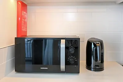 a microwave sitting on a counter next to a coffee maker at Creek Rise Tower 2 - 1BR with Creek Views, Panoramic Living, Dubai Creek Harbour in Dubai