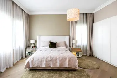 a bedroom with a large bed and a chandelier at Luxurious 4 Bedroom Villa In Emirates Hills in Dubai