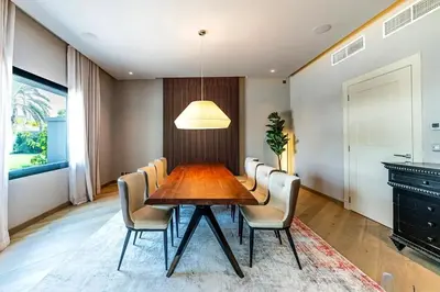 a dining room with a wooden table and chairs at Luxurious 4 Bedroom Villa In Emirates Hills in Dubai