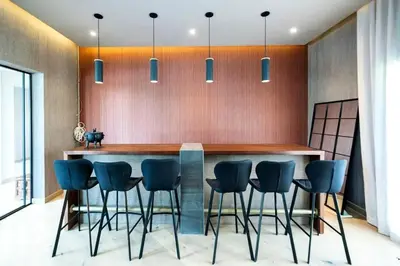 a kitchen with a bar with blue bar stools at Luxurious 4 Bedroom Villa In Emirates Hills in Dubai