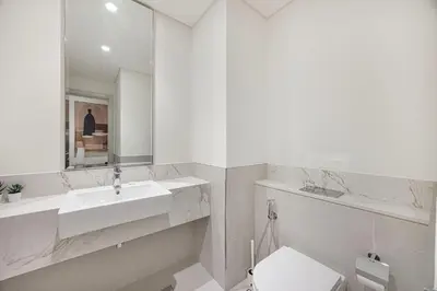 a white bathroom with a sink and a mirror at Seaside Stay at Beach Mansion with Private Beach in Dubai