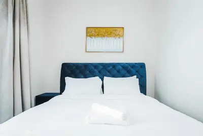 a bedroom with a bed with a blue headboard at Cozy 2 Bedroom Apartment with Balcony Near JBR Beach in Dubai