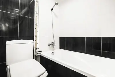 a bathroom with a white toilet and a bath tub at Cozy 2 Bedroom Apartment with Balcony Near JBR Beach in Dubai