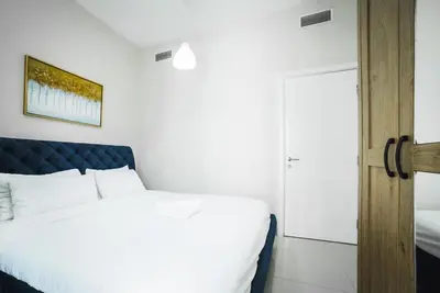 a bedroom with a white bed and a door at 2 Bedroom Apartment JBR Skyline with Balcony in Dubai