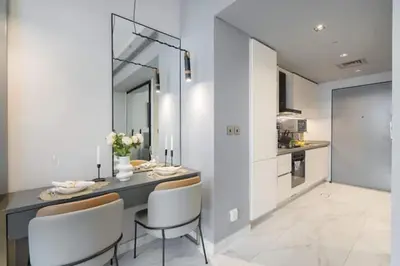 a kitchen with a table and chairs in a room at Vogue Downtown Mag 318 near Burj Khalifa and Dubai Mall, Studio Apartment with Balcony, Pool and City View, Access to all Amenities in Dubai