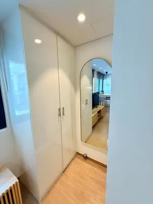 a glass door in a room with a mirror at Warm Minimalist Studio , Walk to Metro , Pool, Gym in Dubai
