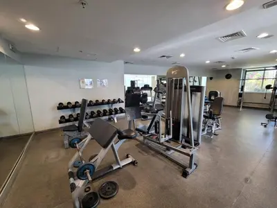 a gym with several treadmills and machines in a room at One Bedroom Apartment in Mag 214, JLT in Dubai
