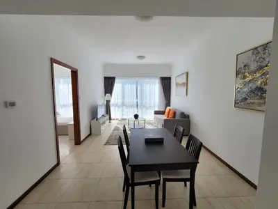 a living room with a table and chairs and a couch at One Bedroom Apartment in Mag 214, JLT in Dubai
