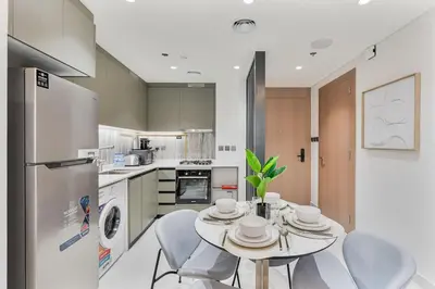 a kitchen with a table and chairs in a kitchen at Luxury 1 Bed Retreat with Balcony in JVT in Dubai