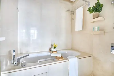 a bathroom with a sink and a bath tub at Frank Porter - Dubai Marina Mall Hotel in Dubai