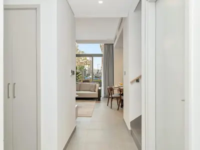 a hallway leading to a living room with white walls at Royal Vista 26 - 4BR Villa at Arabian Ranches III in Nadd Shubayḩ