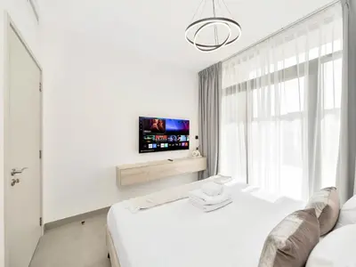 a white bedroom with a bed and a tv at Royal Vista 26 - 4BR Villa at Arabian Ranches III in Nadd Shubayḩ