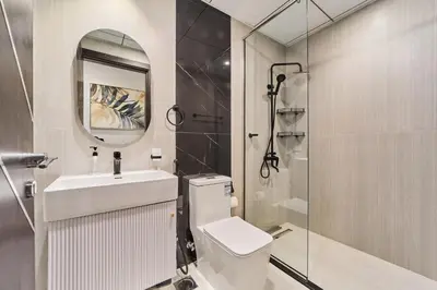 a bathroom with a toilet and a sink and a shower at Elegant 2BR Retreat at Opalz Arjan in Dubai