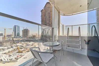 a balcony with a table and chairs and a city at Elegant 2BR Retreat at Opalz Arjan in Dubai