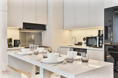 a kitchen with a table with plates and glasses on it at Spacious 4 Bed Villa with Private Pool and Meydan in Dubai
