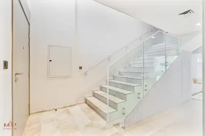 a white staircase with glass railings in a house at Spacious 4 Bed Villa with Private Pool and Meydan in Dubai