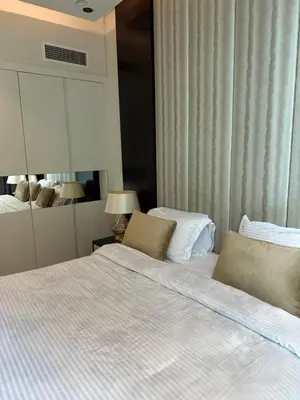 a bedroom with a bed with white sheets and pillows at Damac Upper Crest 2BR Dubai Mall Near 5 min walk in Dubai