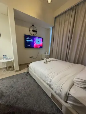a bedroom with a bed and a tv on the wall at Iconic Studio in Azizi 48 with Pool and Gym in Dubai
