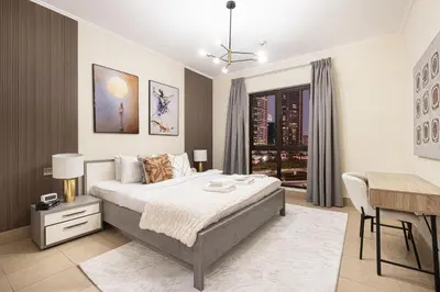 a bedroom with a bed and a table and a desk at Dubai Icon Suite at Miska 2 in Dubai