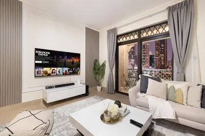 a living room with a white couch and a tv at Dubai Icon Suite at Miska 2 in Dubai