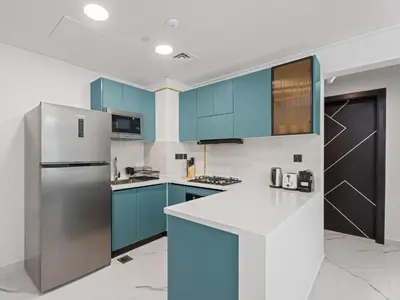 a kitchen with blue cabinets and a stainless steel refrigerator at Opalz Grandeur Escape 2BDR w Mini Pool-06 in Dubai