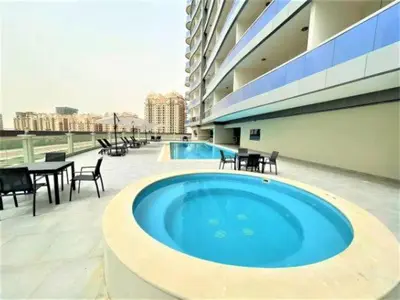 a large swimming pool on the roof of a building at Vogue Sports City Hera Tower Near First Avenue Mall, Studio Apartment with Balcony, Canal and City View, Access to all Amenities in Dubai