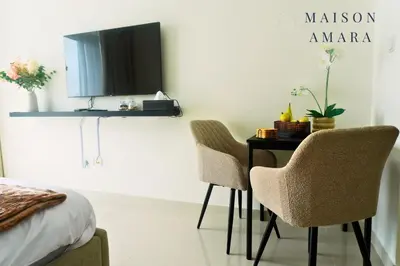 a bedroom with a table with two chairs and a mirror at Modern Luxury Studio Damac Hills With Golf View in Dubai