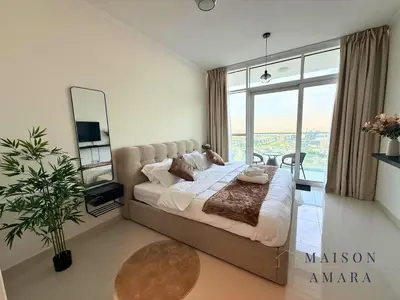 a bedroom with a large bed and a mirror at Modern Luxury Studio Damac Hills With Golf View in Dubai