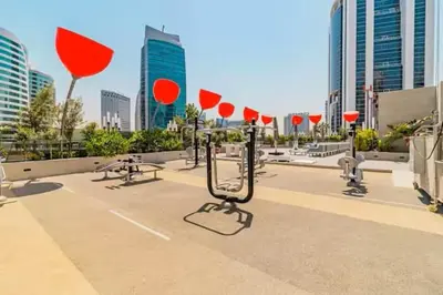 a parking lot with red umbrellas in a city at Vogue Downtown Mag 318 near Burj Khalifa and Dubai Mall, Studio Apartment with Balcony and City View, Access to all Amenities in Dubai