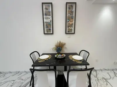 a black table with two chairs and a bowl of food on it at Luxury 1BDR in the heart of Marina Walk to Metro & Promenade #11 in Dubai