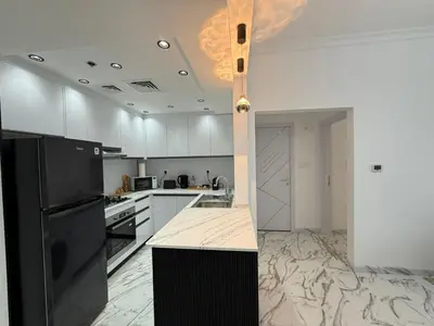 a kitchen with a black refrigerator and white cabinets at Luxury 1BDR in the heart of Marina Walk to Metro & Promenade #11 in Dubai