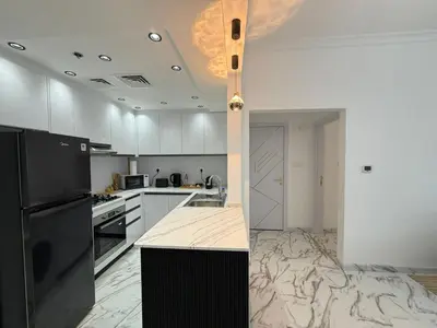 a kitchen with a black refrigerator and white cabinets at Luxury 1BDR in the heart of Marina Walk to Metro & Promenade #11 in Dubai