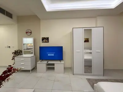 a living room with a tv and a cabinet at Chic Studio in Dar Al Jawhara Residence in Dubai