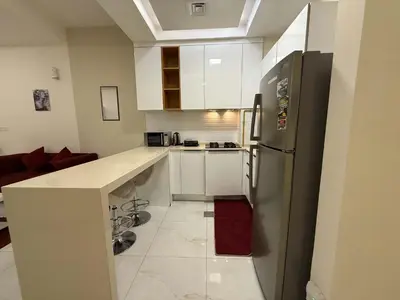 a kitchen with white cabinets and a stainless steel refrigerator at Chic Studio in Dar Al Jawhara Residence in Dubai