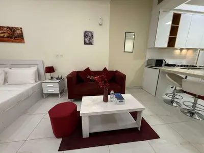 a living room with a red couch and a table at Chic Studio in Dar Al Jawhara Residence in Dubai