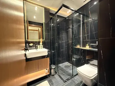 a bathroom with a shower and a sink and a toilet at Sky High Premium 1BR with Stunning Views in Dubai