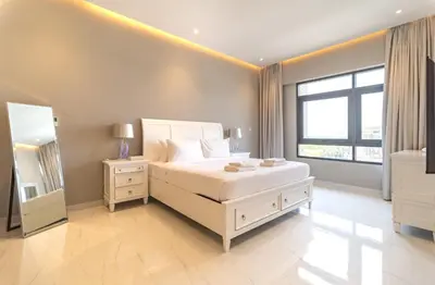 a bedroom with a white bed and a large window at Stunning 3BDR in Al Sidir Greens in Dubai