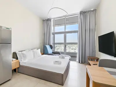 a hotel room with a bed and a large window at Modern Studio In Al-Furjan close to Metro-15 in Dubai